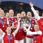 Arsenal players lift the Champions Cup trophy aloft